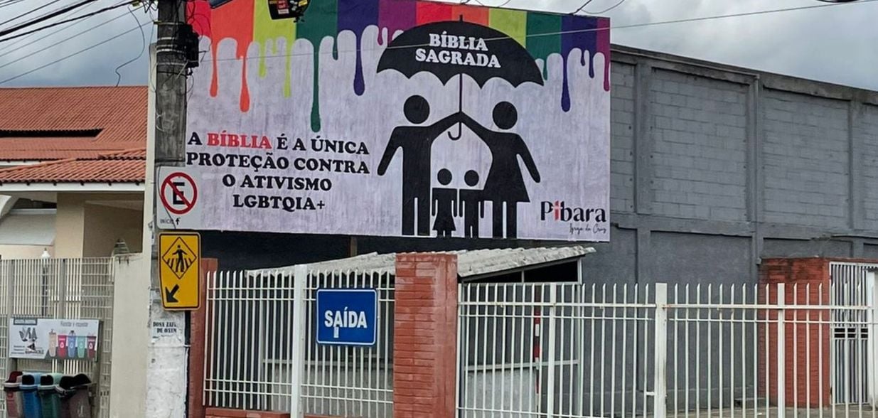 Painel colocado nesta sexta-feira (8) exibe família se protegendo de uma “chuva de arco-íris” e diz que "Bíblia é única proteção contra o ativismo LGBTQIA+"