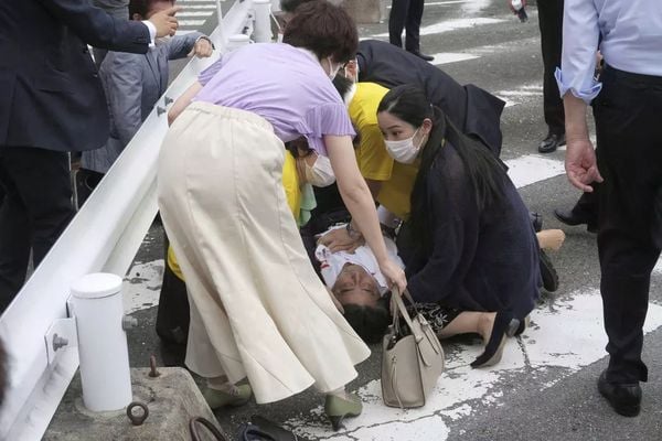 O ex-primeiro-ministro japonês Shinzo Abe no chão, com as mãos no peito, após ser baleado no Japão.