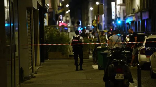 As forças policiais são vistas próximo a um cordão de segurança depois que um atirador matou um indivíduo e feriu outros quatro que estavam sentados no terraço de um bar em Paris, na França.