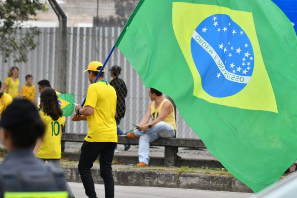 Homem carrega bandeira do Brasil com inscrição "Ordem e progresso" de cabeça para baixo por Fernando Madeira