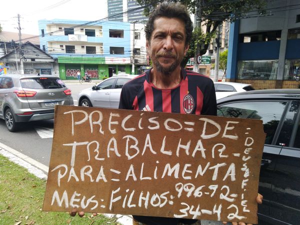 Edalmo leva cartaz escrito ao semáforo para pedir ajuda