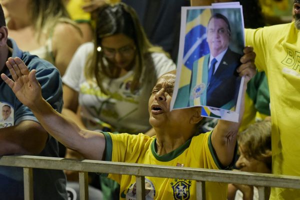 Mulher ergue foto de Jair Bolsonaro enquanto entoa louvores em evento de campanha do presidente da República em Vitória
