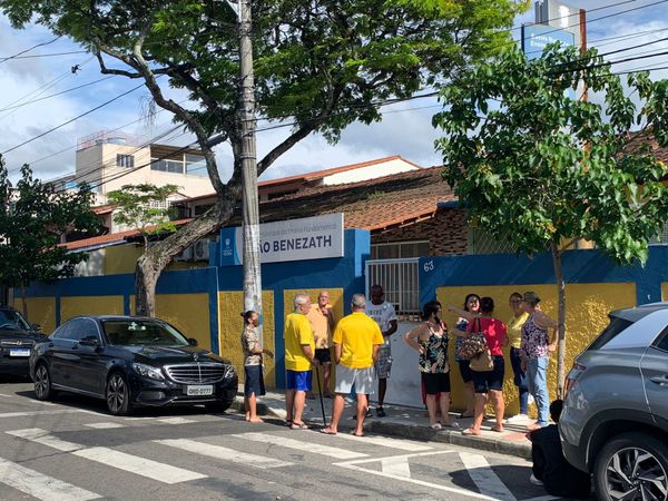 em fila para esperar os portões abrirem na Escola Municipal de Educação Fundamental (Emef) Adão Benezath, em Antonio Honório, Vitória. Por enquanto, a rua está limpa. Nenhum santinho no chão.