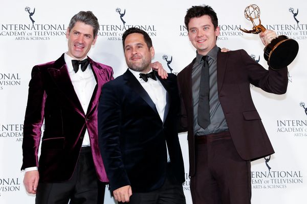 Os produtores Jamie Campbell e Ben Taylor posam junto ao ator Asa Butterfield com a estatueta do Emmy de Melhor Comédia pela série 