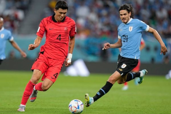 Kim Min-jae (e), da Coreia do Sul, em   lance com Edinson Cavani, do Uruguai