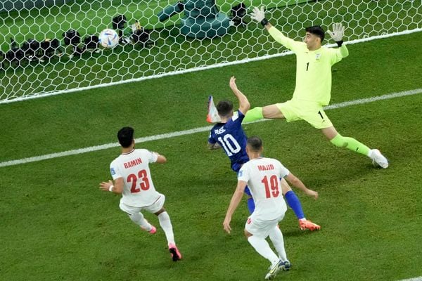 Christian Pulisic (c), dos Estados   Unidos, chuta para marcar seu gol sobre   o Irã 