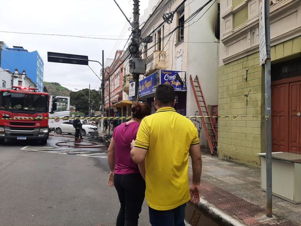 Uma das proprietárias da papelaria aparece sendo consolada após incêndio