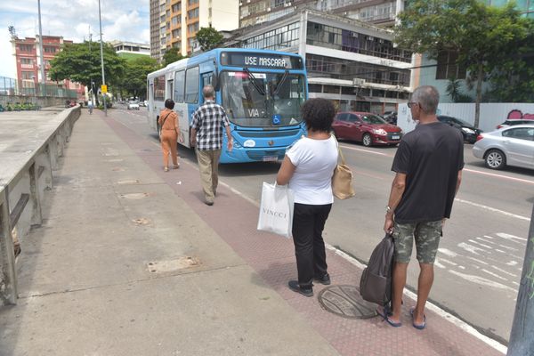 Pessoas esperando ônibus em ponto sem abrigo, Avenida Beira Mar, em Vitória por Ricardo Medeiros