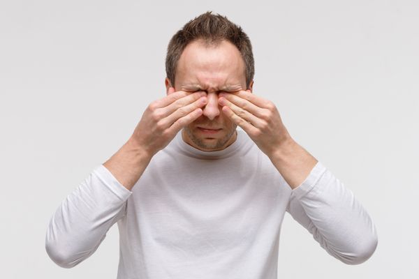 Homem coçando os olhos