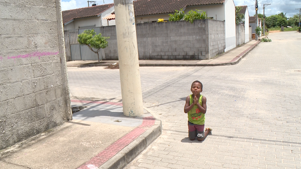 Alexsandro Lima de Almeida, de 7 anos, ora de joelhos e pede por mais segurança em bairro de Linhares