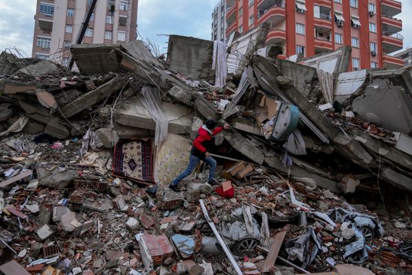 Equipes de resgate procuram por sobreviventes entre os escombros de prédios       desabados na cidade de Adana