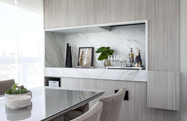 Suavizando o conceito da varanda gourmet projetado por Cristiane Schiavoni, o porcelanato foi utilizado para compor a versatilidade do nicho que faz as vezes do bar e ‘esconde’ churrasqueira, coifa e a cuba, quando necessário