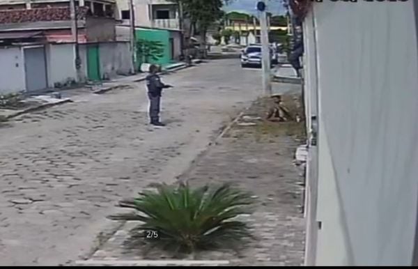 Policial militar aponta arma para o adolescente algemado e no chão, em Pedro Canário