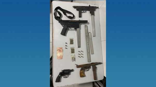 Submetralhadoras, revólver, carregadores e dinheiro que foram apreendidos pela Polícia Militar