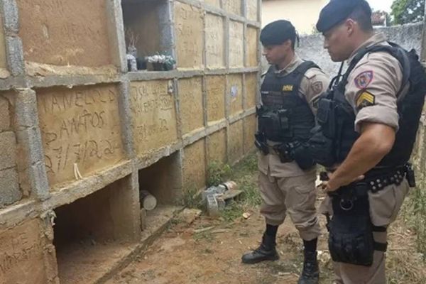 Policiais em frente a túmulo onde mulher foi enterrada viva no cemitério de Visconde do Rio Branco, em Minas Gerais 