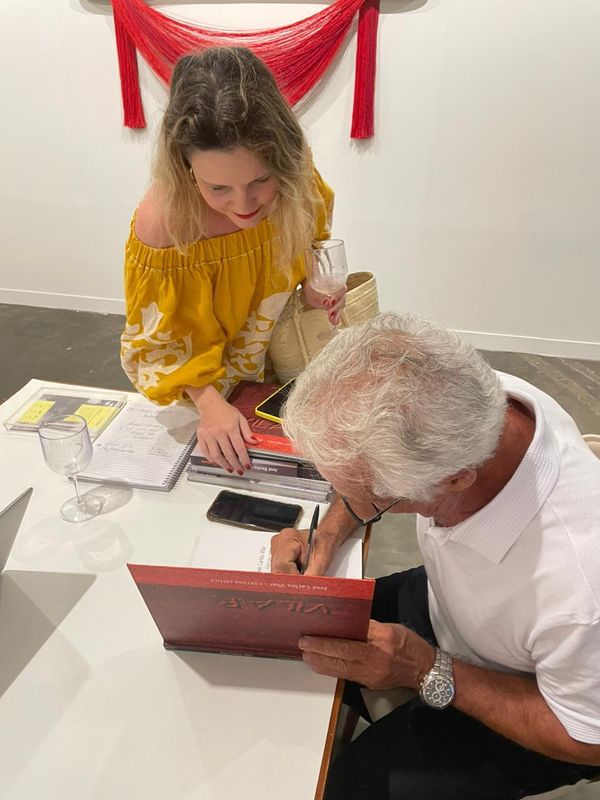 Paula Gribel pegando seu livro assinado pelo artista Vilar