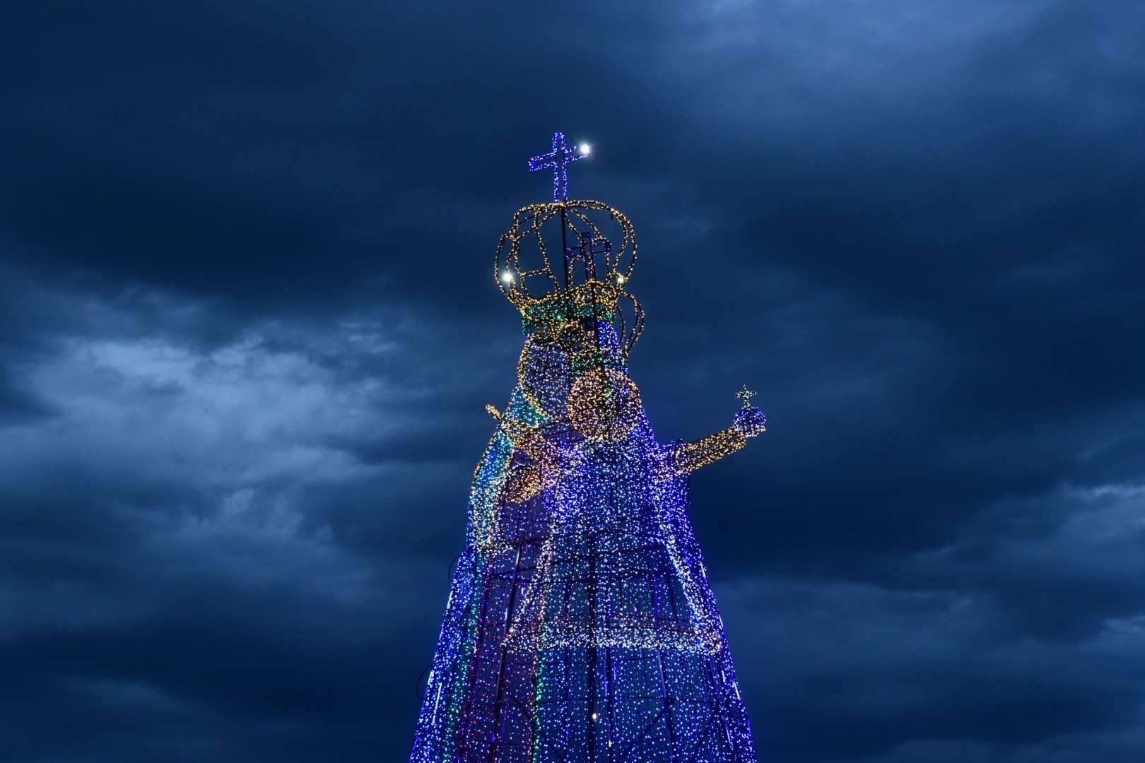 Com 17 metros e mais de 100 mil lâmpadas, estrutura da Santa Iluminada foi acesa neste sábado (8), na Praia da Costa, em um convite para a festividade religiosa