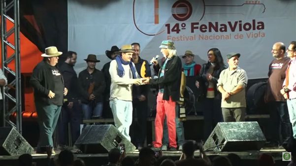 Zé Geraldo entregando o troféu do Fenaviola a Saulo Santos Fagundes, de Goiás. Ele foi o vencedor da 14ª edição com a canção ‘Saudade do Zeca’