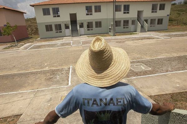 Homem observa parte do complexo de apartamentos na retomada do Minha Casa, Minha Vida em Santo Amaro (BA) 
