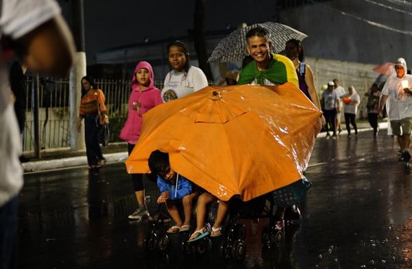 Romeiros usam guarda-sol para proteger crianças da chuva na Romaria dos Homens por Fernando Madeira