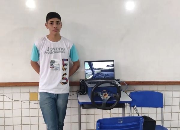 Estudante Daniel Lima Silva de Oliveira, de Ibatiba, com o simulador de corrida de carros construído usando sucatas