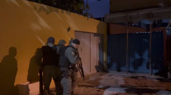 Policiais chegando a casa de um alvo da operação, em Conceição da Barra