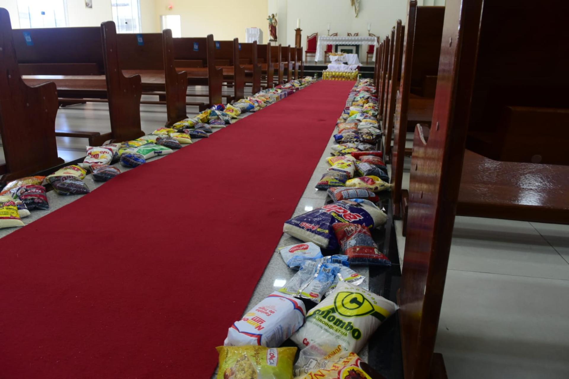 Na parte interna da igreja Católica do bairro Guaranhuns, um tapete de alimentos feito com 25 cestas básicas que foram doadas