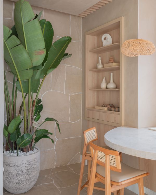 Neste projeto Tamara Rodriguez Arquitetura, a marcenaria bege recebeu um toque especial com a parede de caquinhos