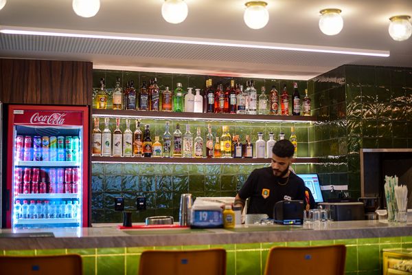 No balcão do bar, assentos são originais da arquibancada do estádio do Pacaembu, em SP por Vitor Jubini