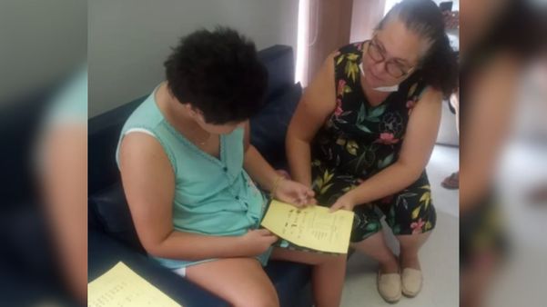 Thais e a mãe durante um exercício para reaprender a ler