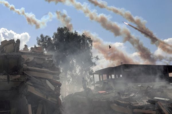 Foguetes Qassam sobrevoam edifícios destruídos após ataques aéreos israelenses na cidade de Gaza, no centro da Faixa de Gaza, nesta quinta-feira, 19 de outubro de 2023. O conflito, que chega ao seu 13º dia, já matou 4,6 mil pessoas entre israelenses e palestinos.