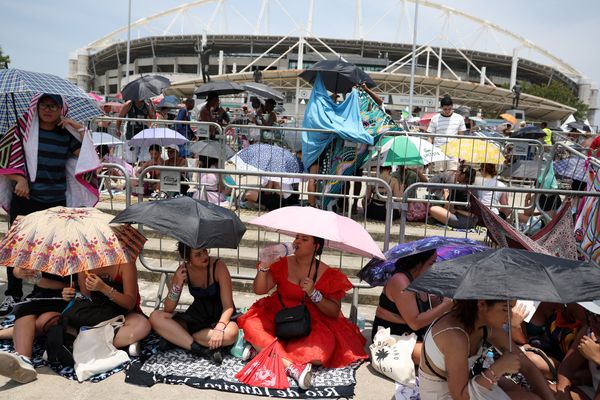 Fãs usam sombrinhas para se proteger do calor enquanto esperam show de Taylor Swift no Rio de Janeiro 