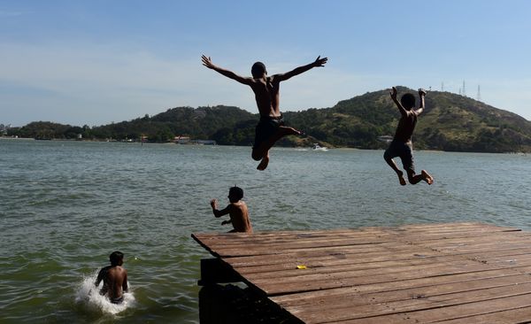 Jovens pulam no mar em Vitória por Ricardo Medeiros