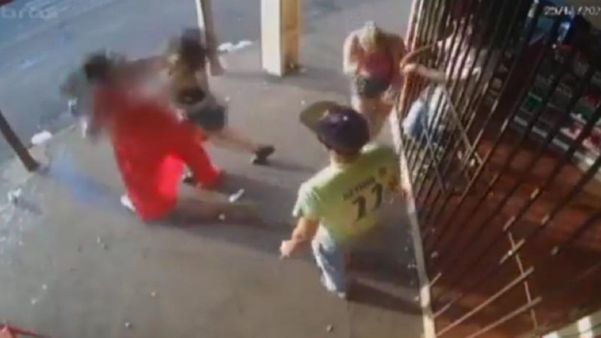 Imagens mostram momento da briga entre a suspeita, de vestido laranja, e a vítima, que cai no chão