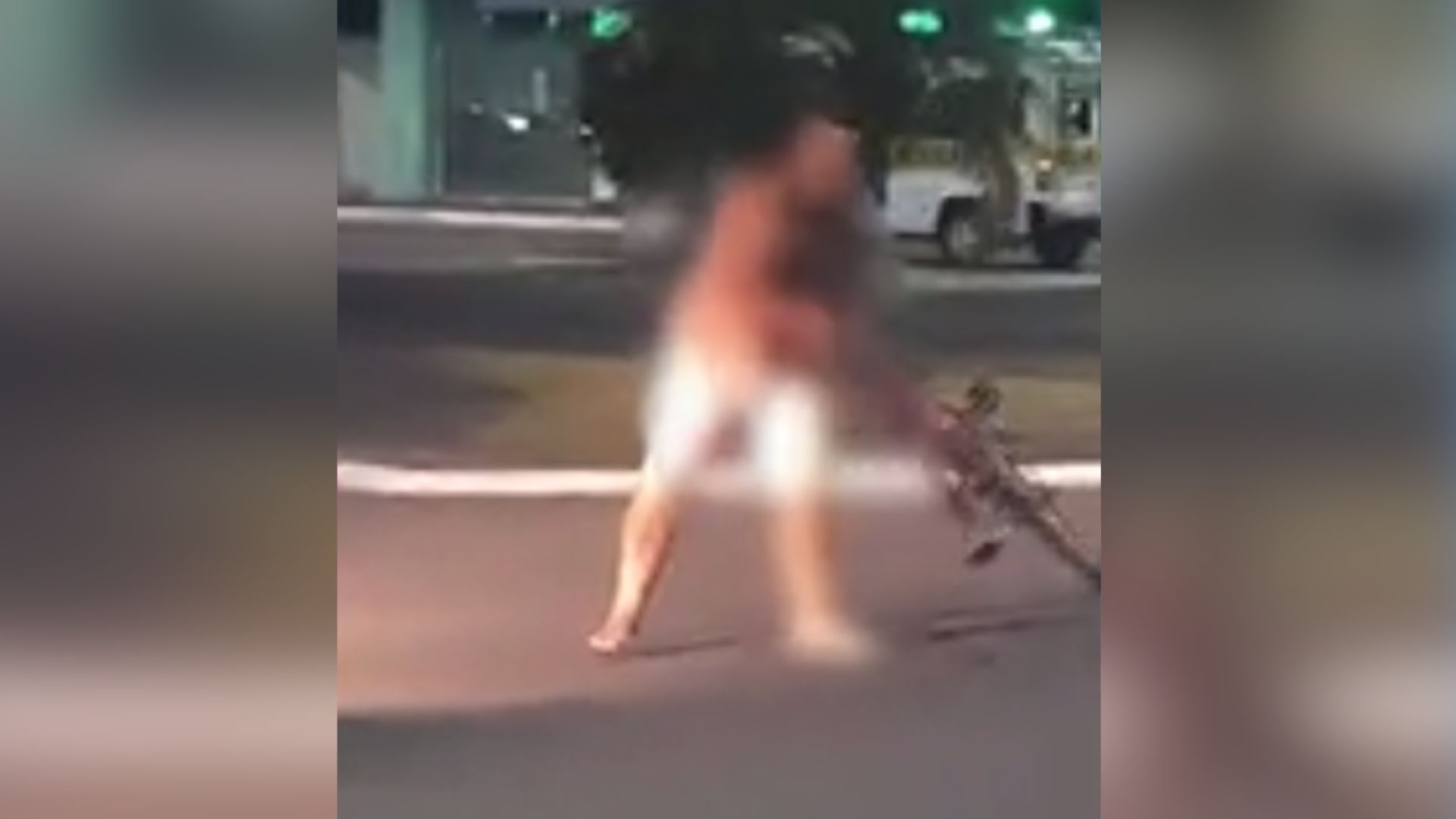 Os vídeos, gravados por alguns segundos, mostram que o homem sem roupa tenta arrancar o retrovisor de uma caminhonete, anda pela rotatória e joga a bicicleta no carro que passava pela avenida