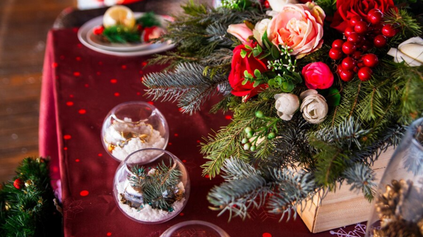 Vasos com enfeites e flores trazem um toque aconchegante a mesa de Natal. 
