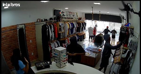Quatro indivíduos invadiram a loja e roubaram várias peças de roupas, óculos, relógios, um celular e cerca de R$ 100; após o roubo, eles fugiram pulando o muro de uma escola