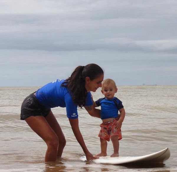 Angélica Von Doellinger ensinando seu filho Lucas a surfar