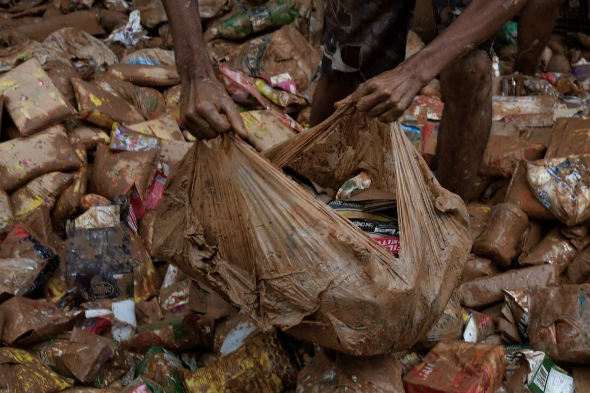 Pessoas tentam encontrar alimentos em meio à lama da destruição em Mimoso do Sul