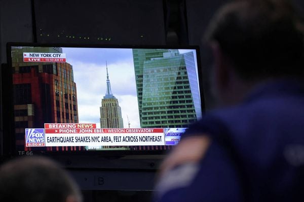 Uma televisão na Bolsa de Valores de Nova York (Nyse) mostra alerta de notícias sobre o terremoto na cidade 