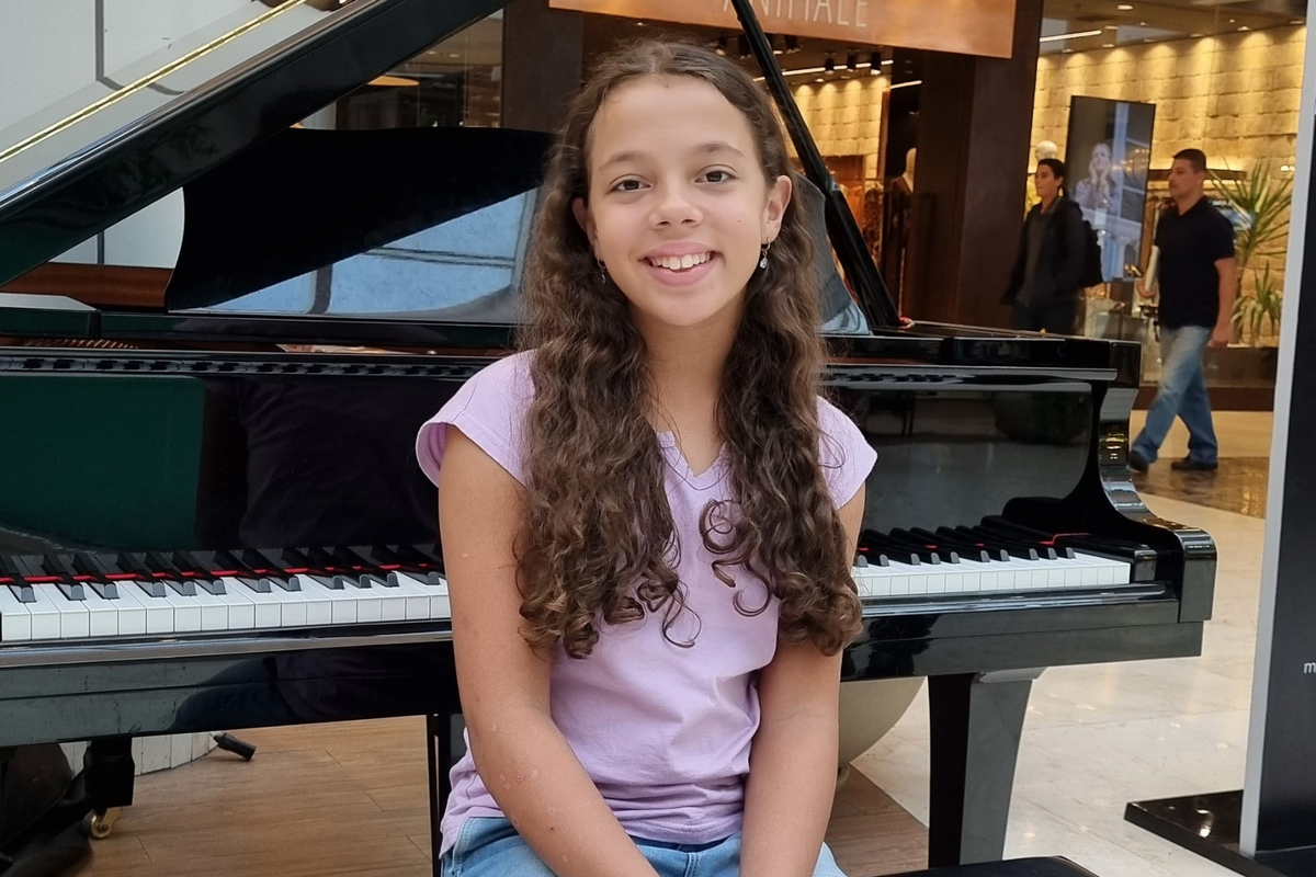 A pequena Ana Julia Briske de Souza bate ponto na Praça do Piano