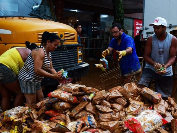 Pessoas tentam encontrar alimentos em meio à lama da destruição em Mimoso do Sul por Fernando Madeira