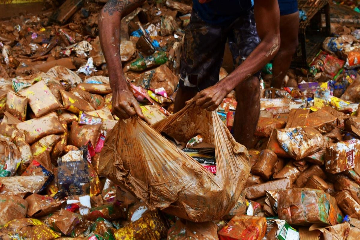 Pessoas tentam encontrar alimentos em meio à lama da destruição em Mimoso do Sul