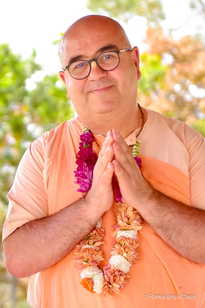Chandramukha Swami em gesto de saudação, diante de um jardim