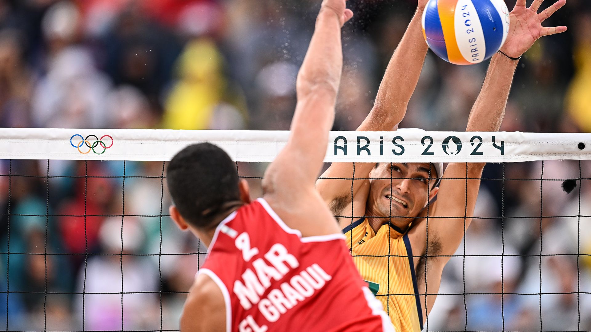 André Stein sobe para bloquear marroquina em partida de vôlei de praia