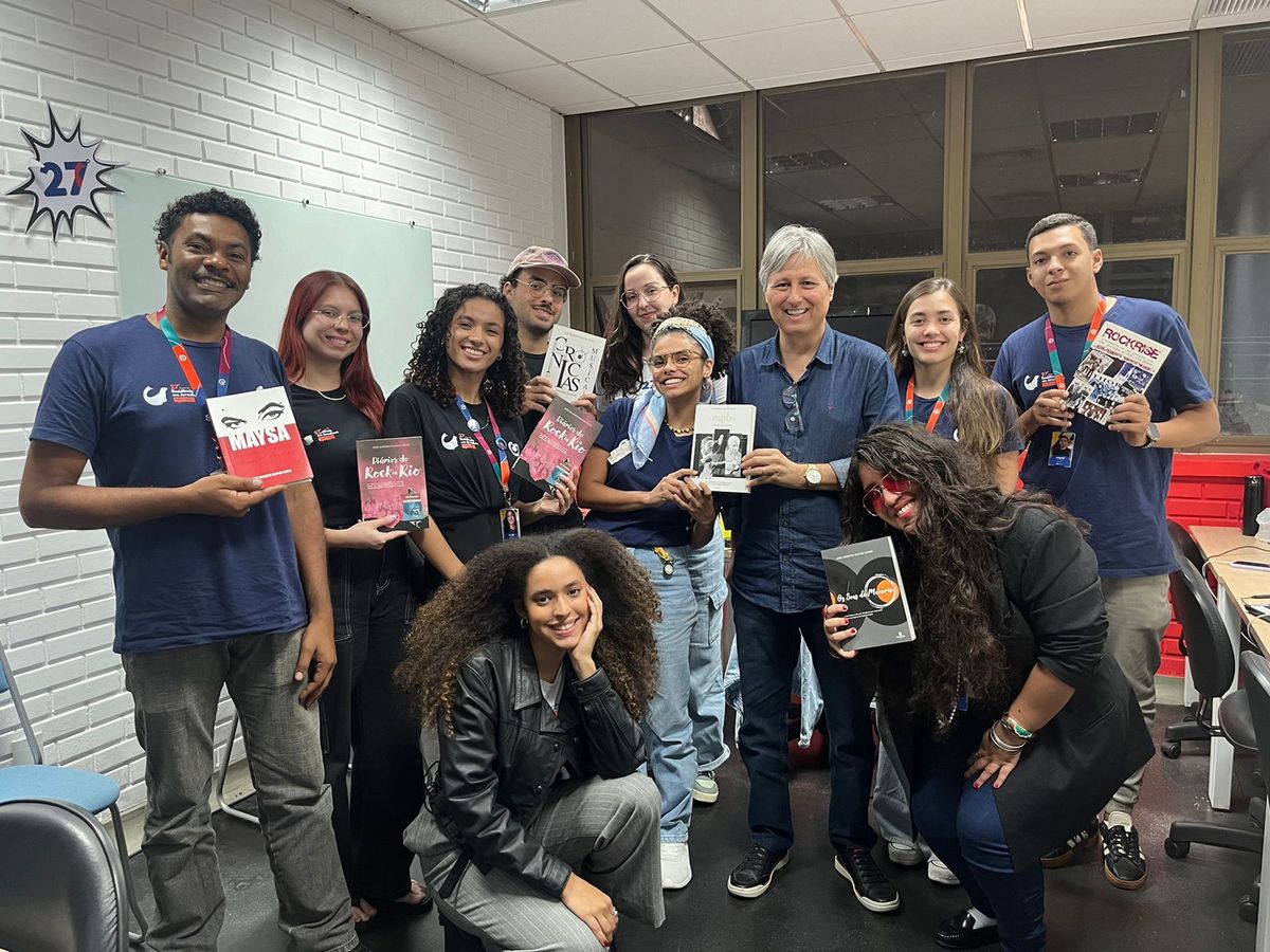 Aluna de residência lendo livro de José Roberto Santos Neves, seus livros, e a 27ª Turma de Residência em Jornalismo