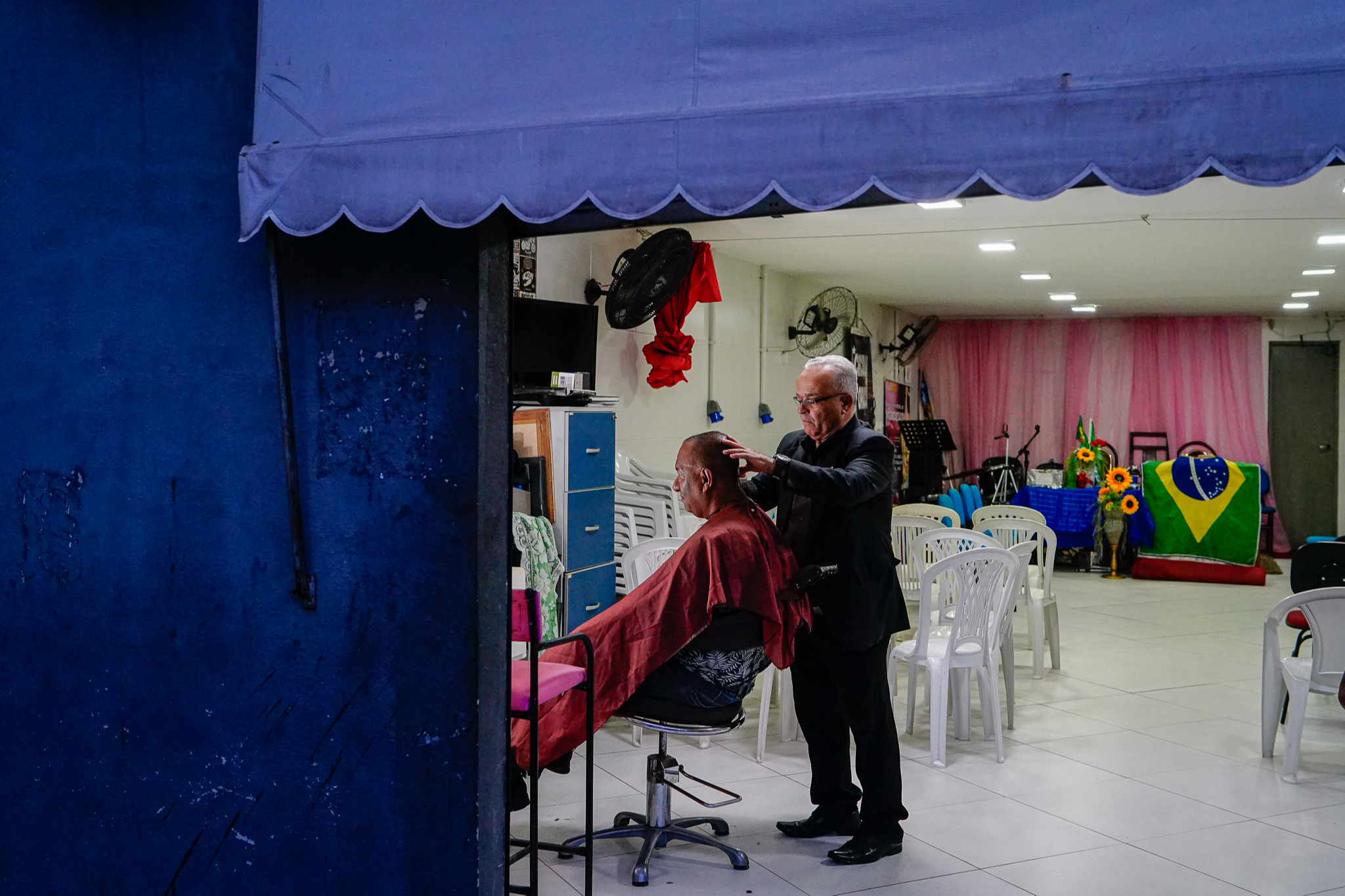 Pastor Genivaldo Cardoso atende cliente em barbearia que funciona dentro da Igreja Assembleia de Deus