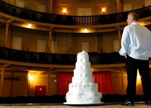 Júnior Vieira, no Teatro Sesc Glória, diante de um belo e imponente bolo, uma das suas obras de arte