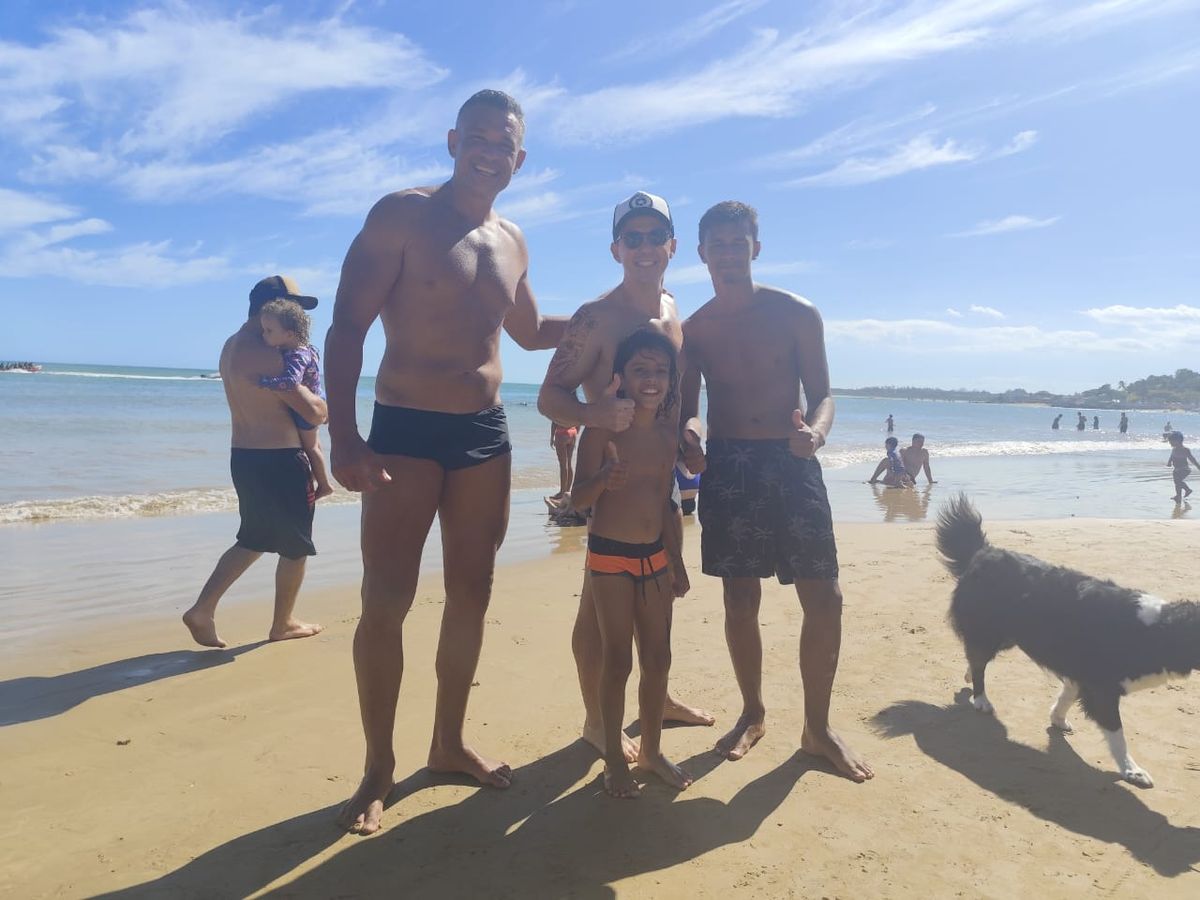 Francisco, de 10 anos, junto com banhistas que ajudaram a resgatá-lo após o menino ficar à deriva em alto mar em bolha de plástico na praia de Anchieta, Espírito Santo