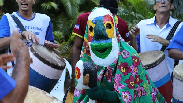 Personagem nascido da criatividade e da dor dos escravizados, ícone da identidade cariaciquense, volta ao centro do debate ao ser alvo de ataques em escolas municipais